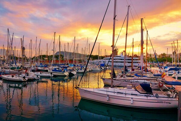 Dawn on the pier, in the middle of yachts