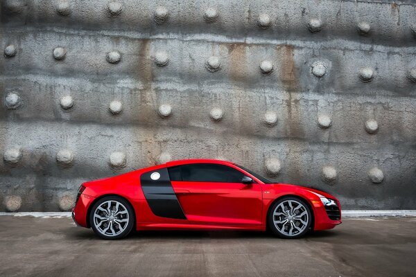 Vue latérale rouge Audi sur fond de mur gris