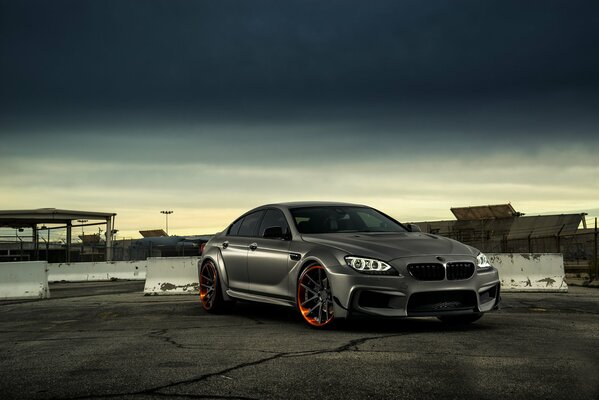 Grau matt bmw m6 auf Himmel und Gebäude Hintergrund