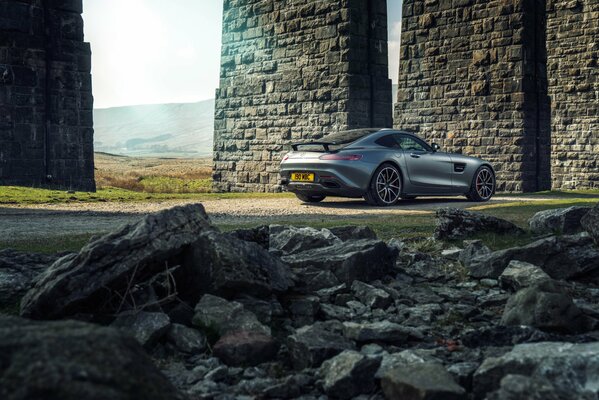 Grey Mercedes amg gt s 2015 on the background of stone walls