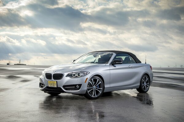 Voiture BMW convertible argent sur route mouillée