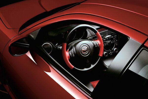 Mazda rojo, volante, interior a través de la ventana del conductor