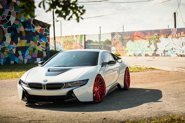 Auto elettrica messa a punto da BMW sullo sfondo di street art