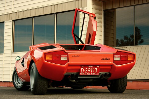 Czerwone lamborghini, countach lp400 z 1974 roku na tle budynku