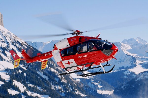 Helicóptero de rescate se cierne sobre las montañas en invierno