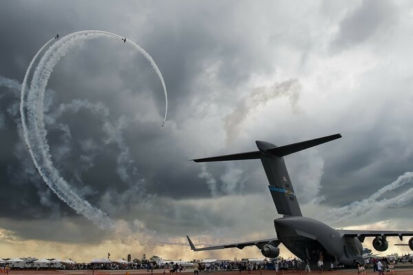 Спираль самолетов на фоне темного облака