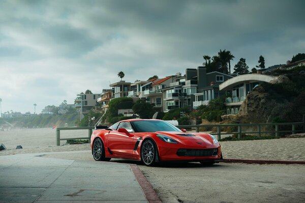 Corvette rojo cerca de las casas