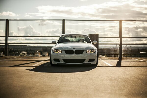 A white sports BMW on a background of clouds