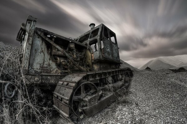 El viejo tractor está solo. noche, sombrío