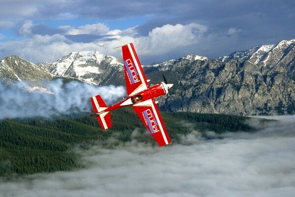 Piccolo aereo rosso sullo sfondo di montagne innevate