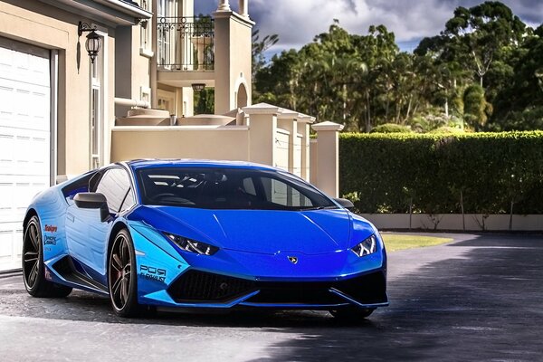 Lamborghini azul cerca de la casa de lujo