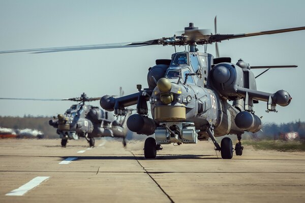 Helicopters at the airfield take off along the highway