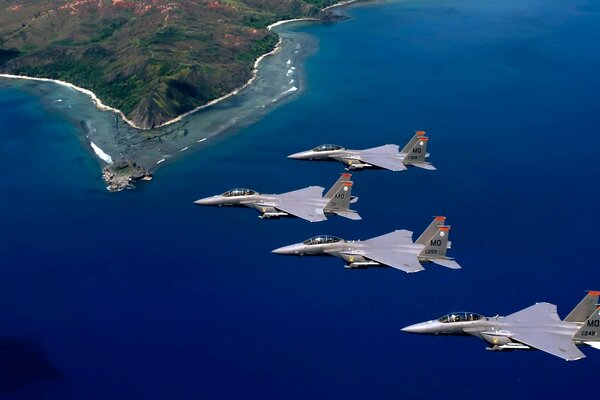 Military fighter jets fly over the sea