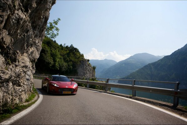 A red sports car among the mountains and serpentine
