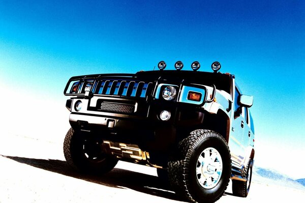 Niebieski SUV Hummer na pustyni