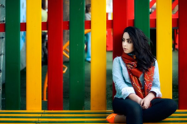 Una mujer triste en un fondo de valla de color