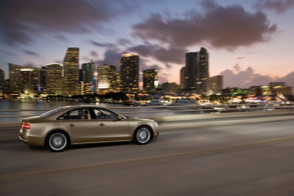 Audi a8 rushes along the highway against the background of sunset