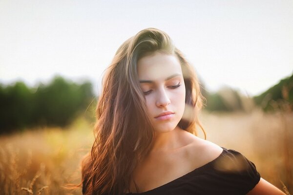 Una ragazza calma sta nel campo e guarda giù