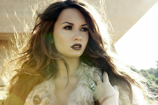 Demi Lovato with flowing hair looks into the distance