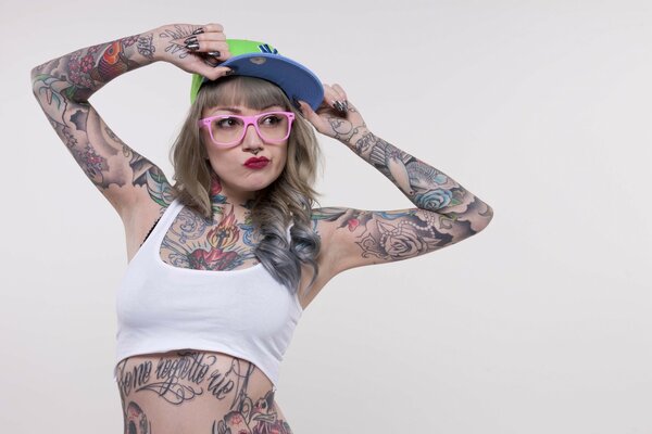 Fille tatouée dans un t-shirt et des lunettes de soleil