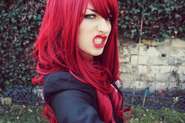 Fille avec des cheveux rouges et des piercings sur la lèvre