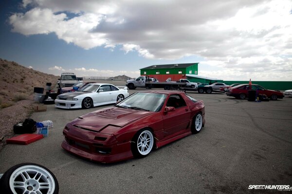 Red mazda rx7 on the background of JDM cars