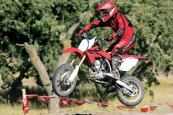 Salta su una moto da cross rossa