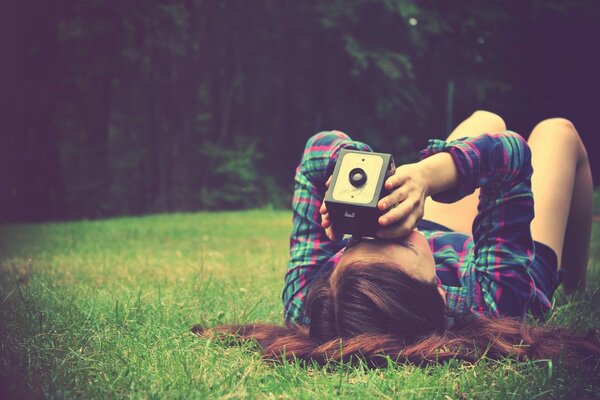 Ragazza sull erba verde si trova e scatta foto