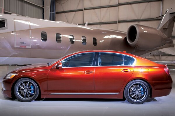 Lexus gs-350 na tle samolotu w hangarze