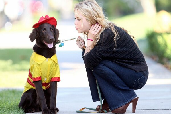 Chien dans les vêtements est assis sur la piste et à côté de sa fille se pencha