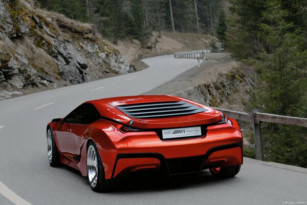 Red bmw m1 rushes along a winding road