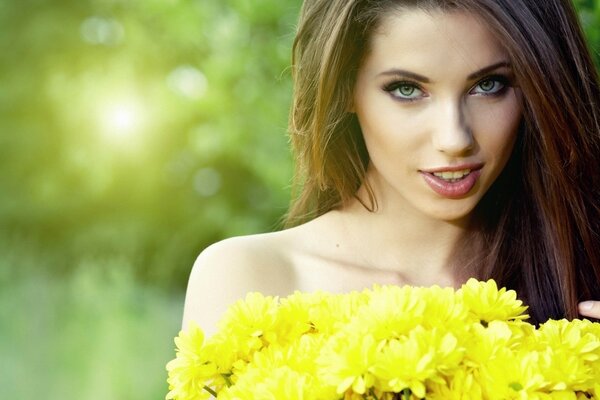 Brünette Mädchen mit einem Strauß gelber Blumen