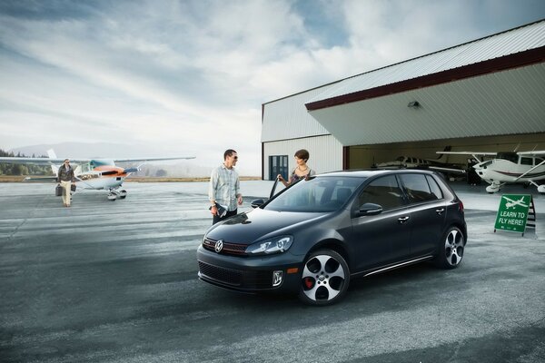 Volkswagen in the parking lot near the aircraft hangar