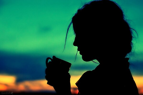 Silhouette d une jeune fille avec une tasse dans le profil