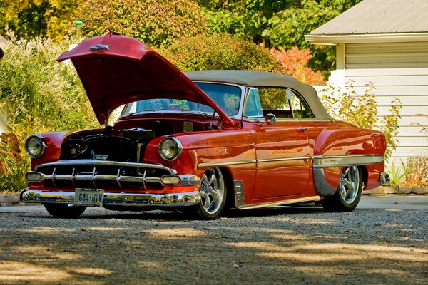 Red retro car in autumn landscape