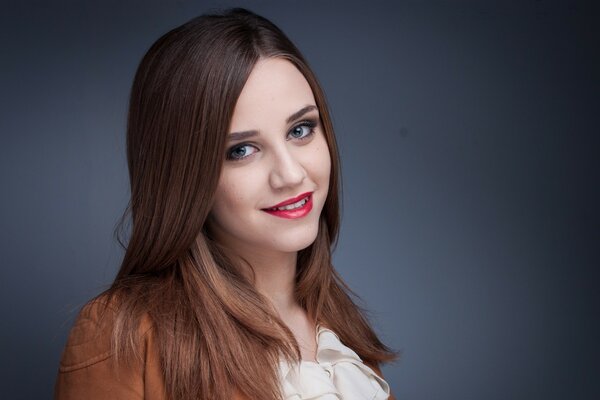 Jolie brune avec rouge à lèvres rouge sur les lèvres souriant