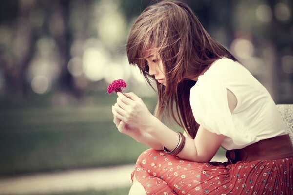 Triste morena con una flor en sus manos