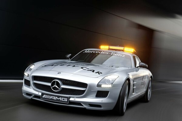 A mercedes sls car with its headlights on rushes down the road