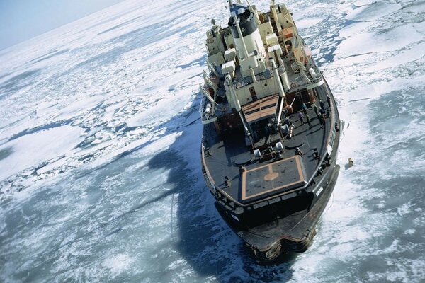 A ship in the Arctic on an ice floe in the middle of the water