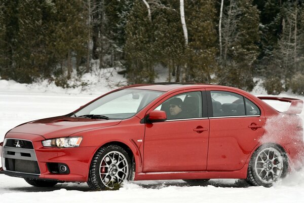 Il Lancer rosso mucibishi entra in curva sulla pista invernale