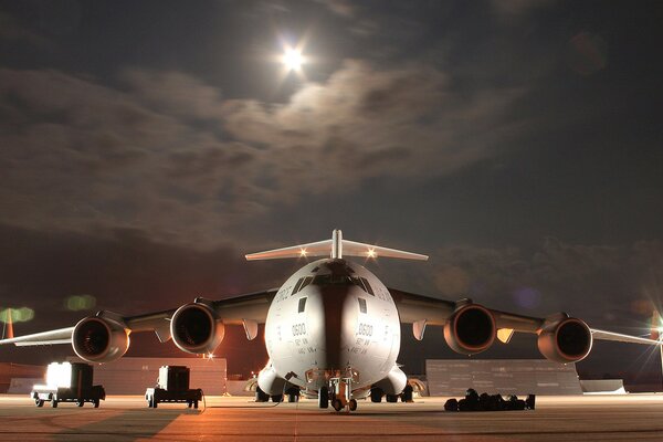 The plane is illuminated by floodlights at night