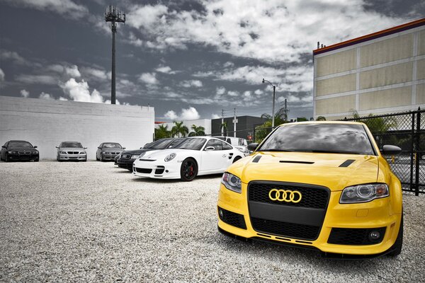 Audi gialla vicino ad altre macchine