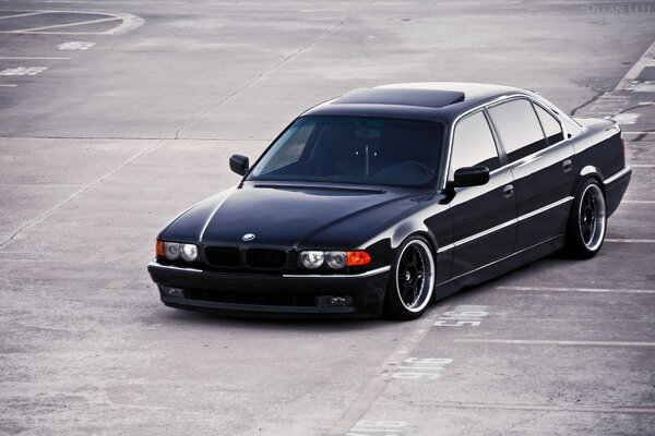 Photo of a Black BMW on gray asphalt