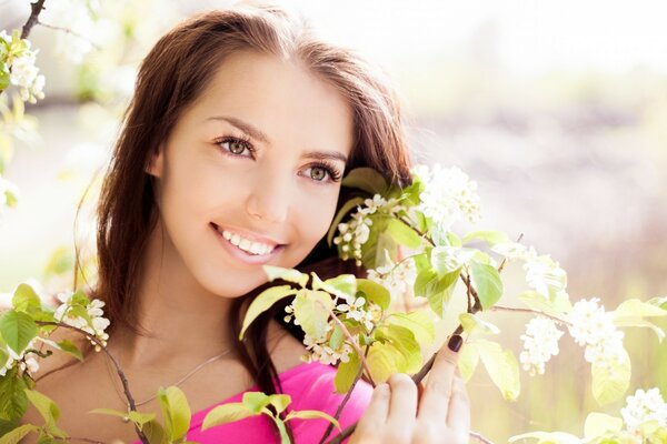 Una chica sonriente y un árbol en flor