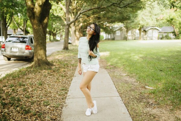 Mujer asiática con gafas de pie en el parque