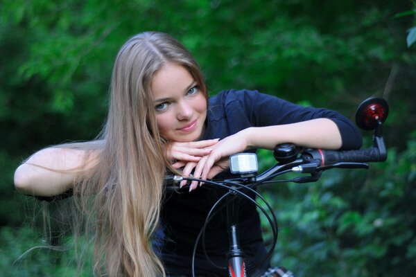 Blonde Mädchen sitzt auf einem Fahrrad