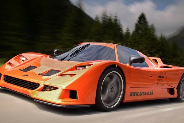 La voiture orange orca c113 roule à pleine vitesse