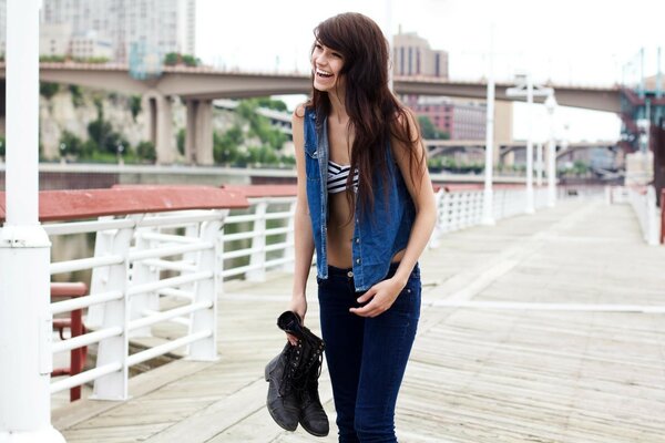 Brunette tenant des chaussures et des Rires