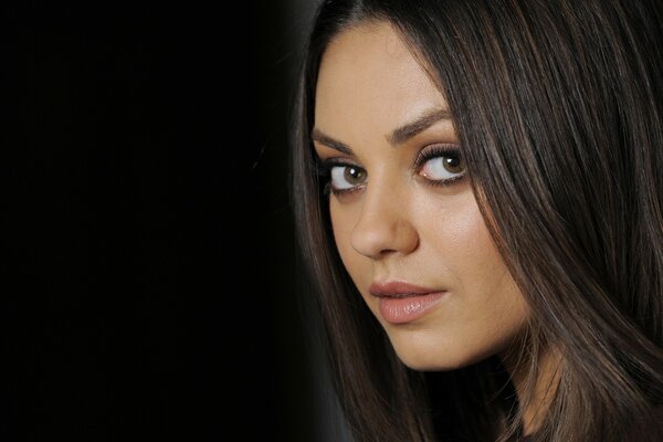 Mila Kunis na czarnym tle