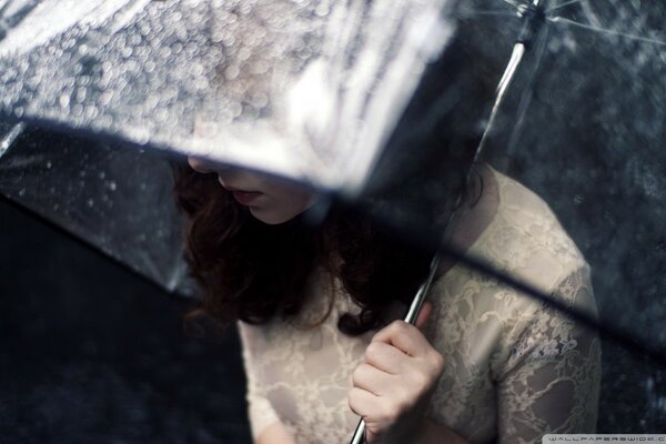 A girl under an umbrella in a white dress